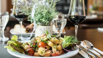 Gemischter Salat mit Croûtons und einem Glas Rotwein